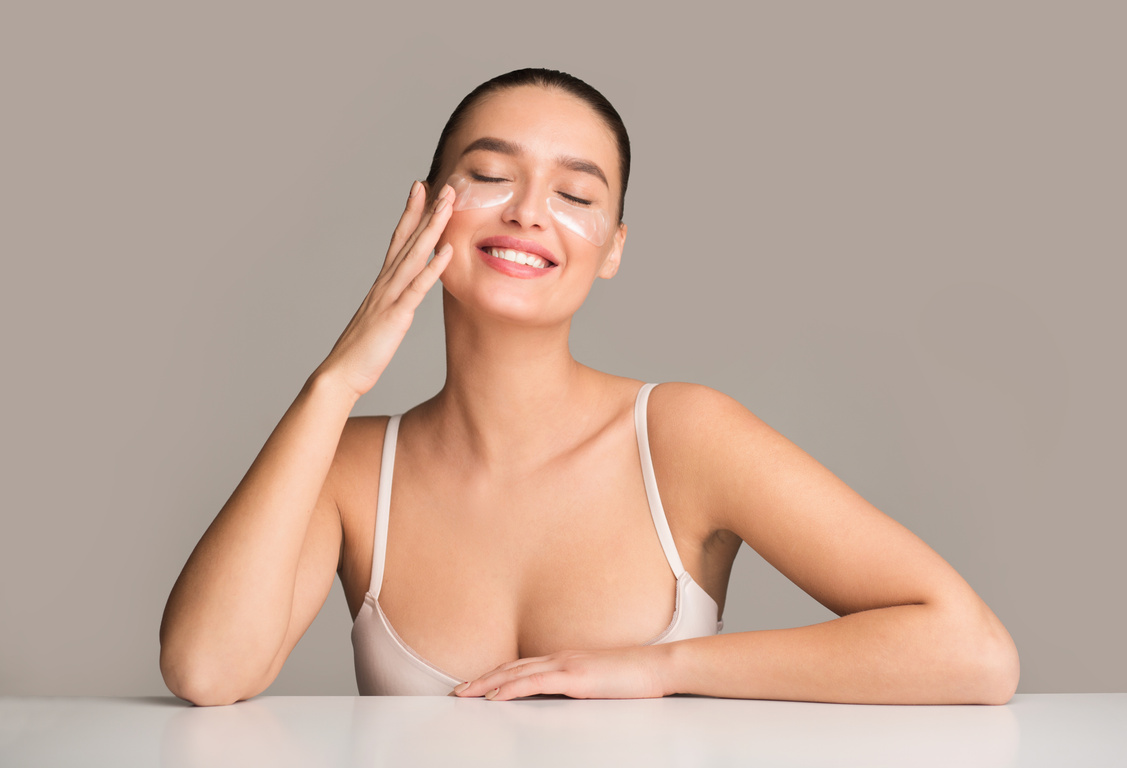 Happy woman with collagen pads under eyes